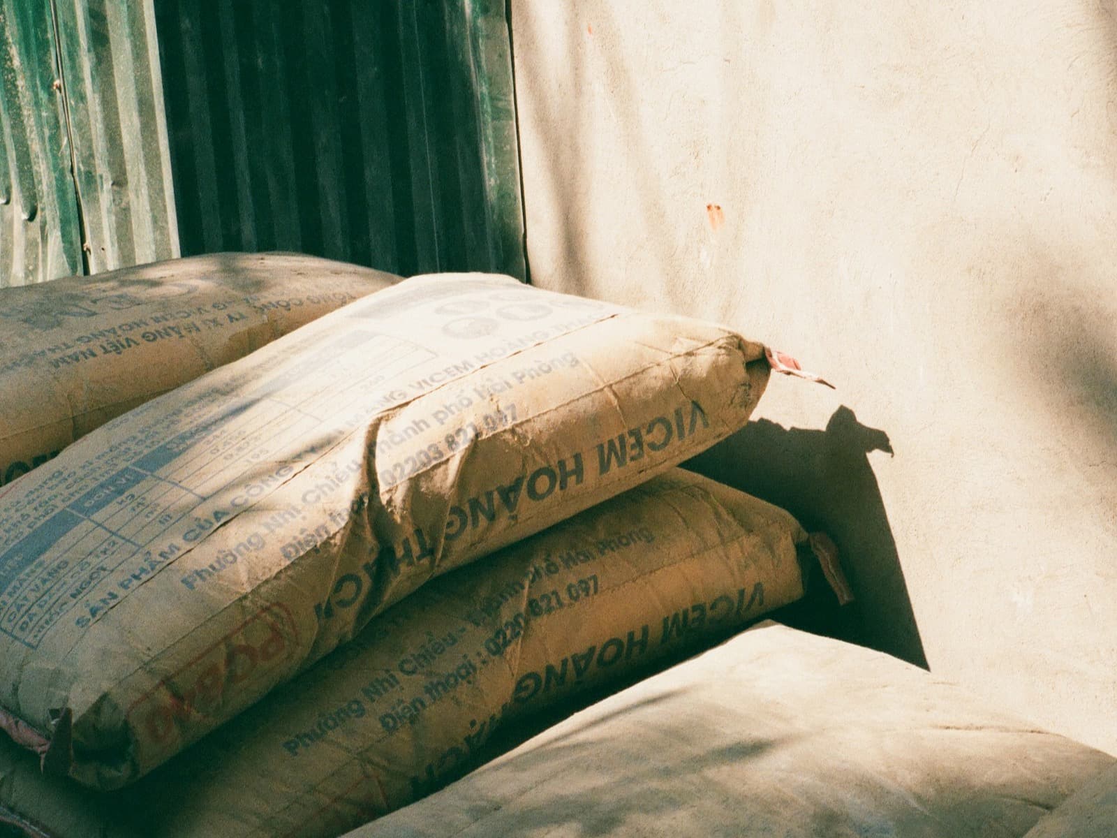 Branded cement sacks stacked in sunlight at a worksite